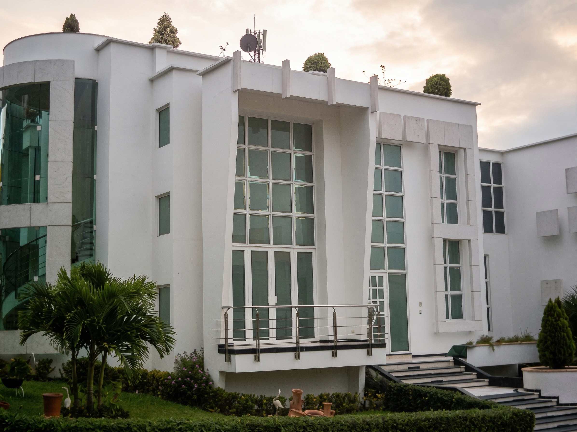 Casa Isla del Conde: fachada de acceso con gran paño de vidrio y barandas metálicas