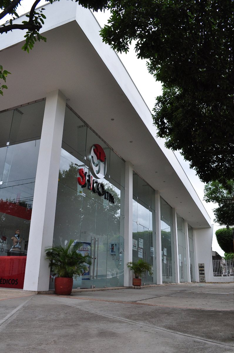 Plaza Di Bianco: fachada sobre la avenida con columnas blancas y vidrio