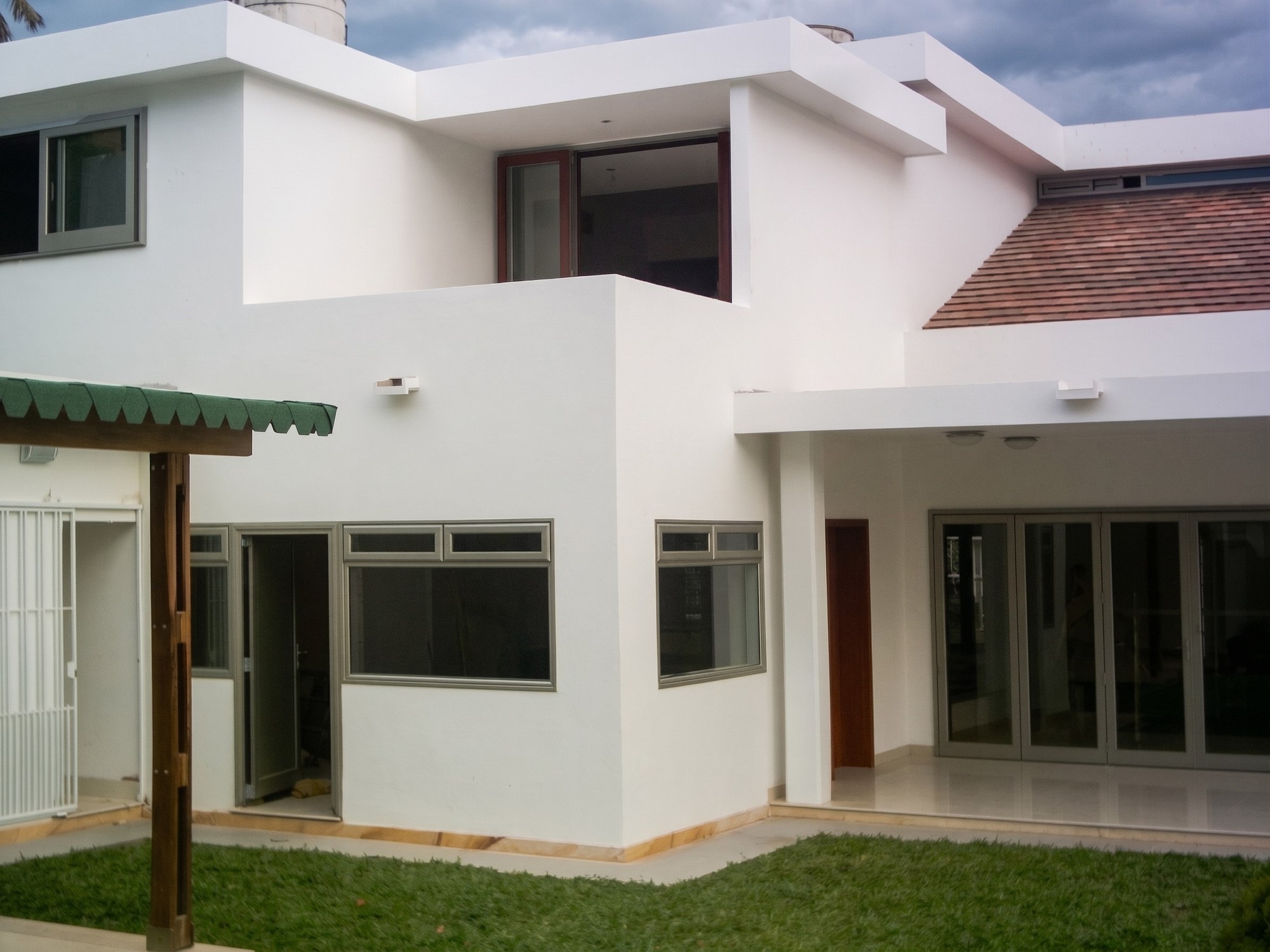 Fachada posterior terminada con terraza, ventanas de aluminio y jardín